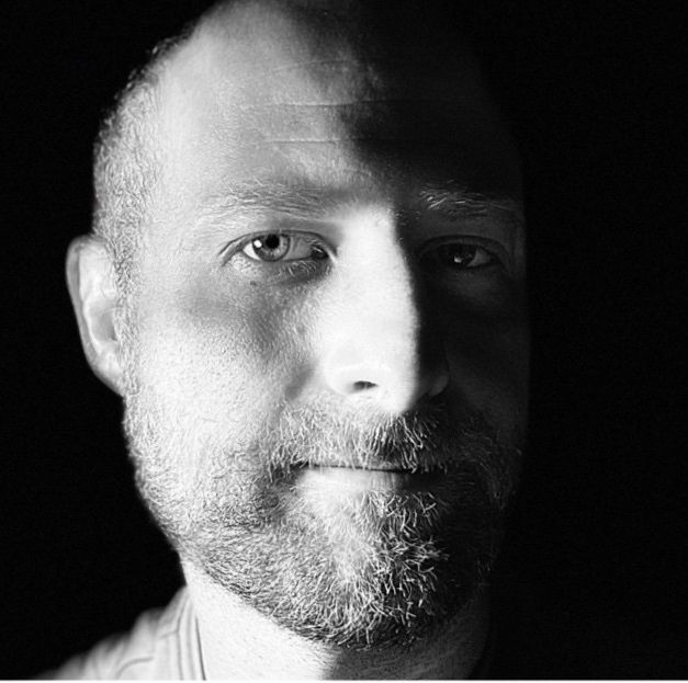 Kyle H. Chase, half in light and half in shadow